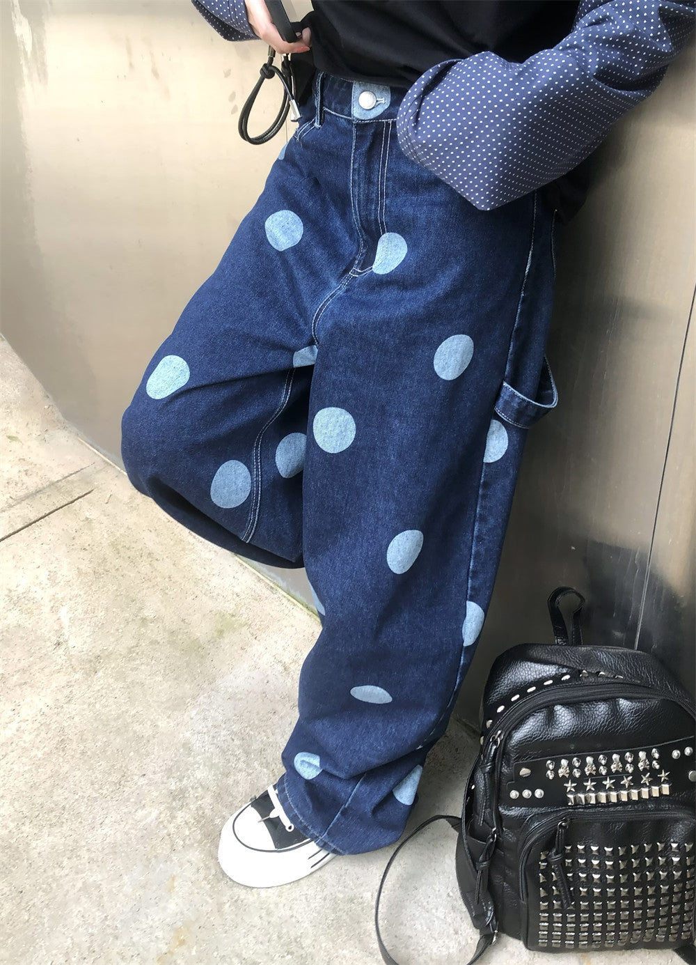 Model wearing wide-leg polka dot jeans, angled front view