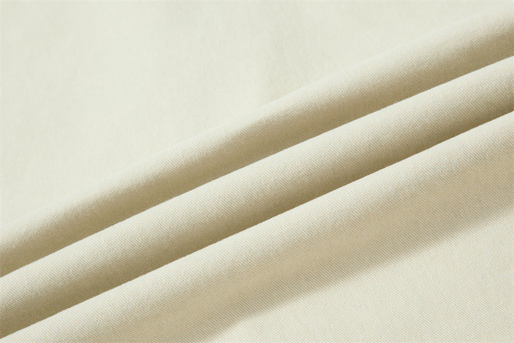Close-up of cream fabric folds with fine twill texture