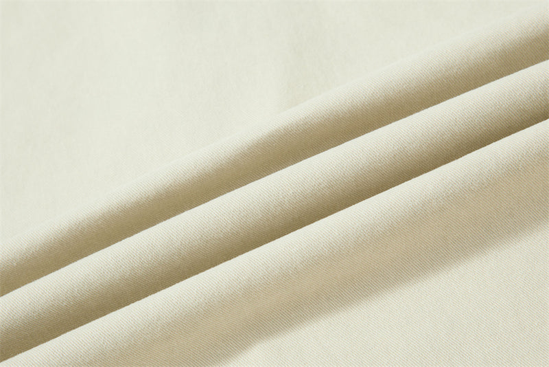 Close-up of cream fabric folds with fine twill texture