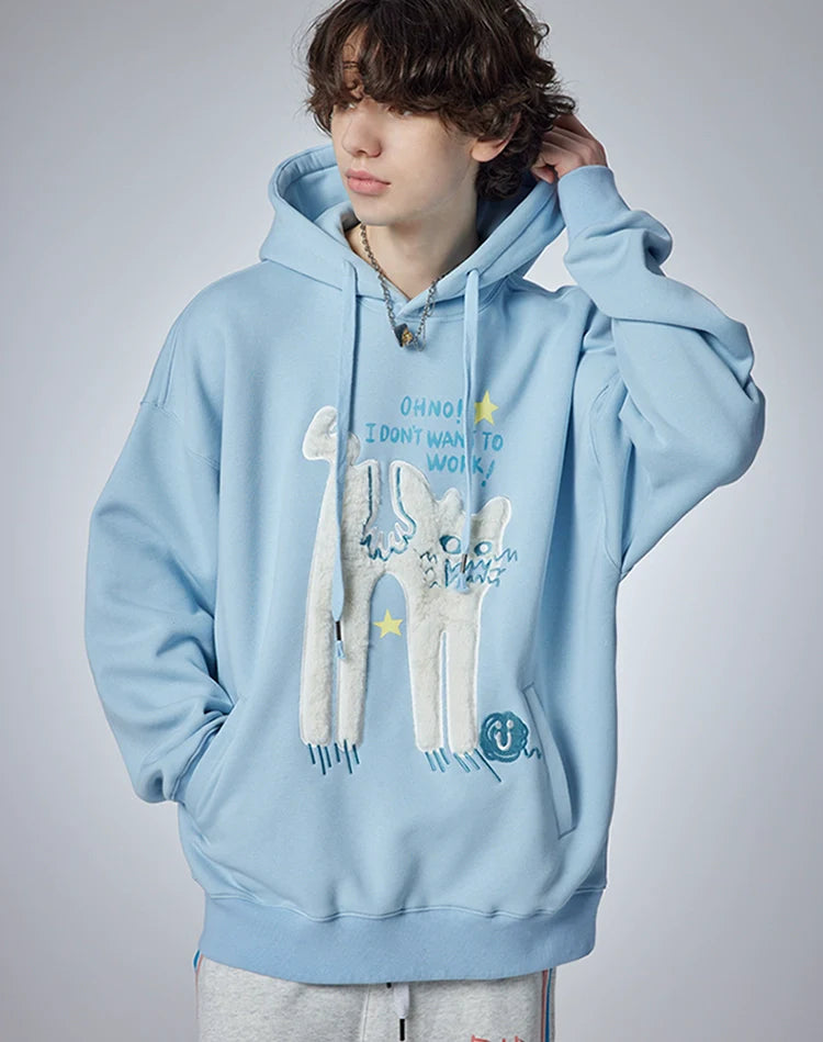 A person wears Seakoff's "Oh No! I Don’t Want to Work!" oversized hoodie, adorned with a cute lazy cat design. They stand against a plain background, gazing sideways with one hand behind their head, exuding a casual streetwear vibe.