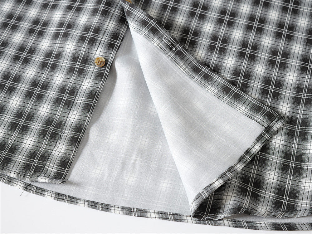 Inside view of black plaid shirt hem showing white lining