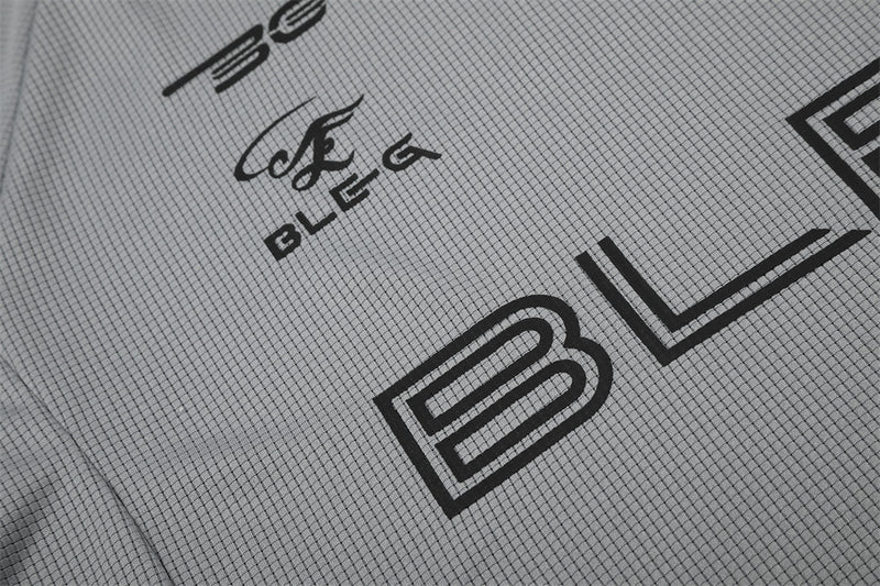 Close-up of gray shirt graphic showing BLEG lettering and large B print