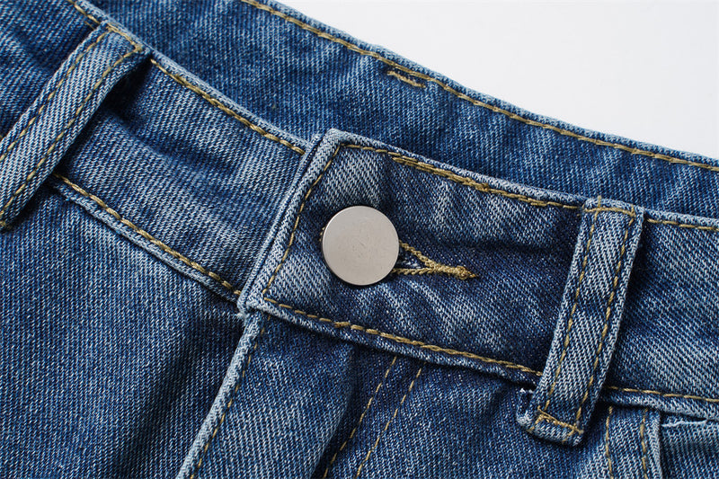Close-up of silver button on blue denim waistband