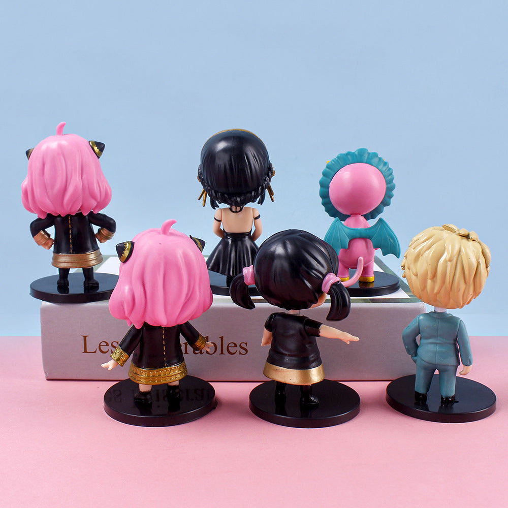 The Spy × Family 6-Piece PVC Figure Set includes stylized figurines such as Anya, Loid, and Yor with vibrant hair and outfits. Perfect for anime collectors, these figures face away on black bases against a pink and blue backdrop. The box supports two for extra flair.