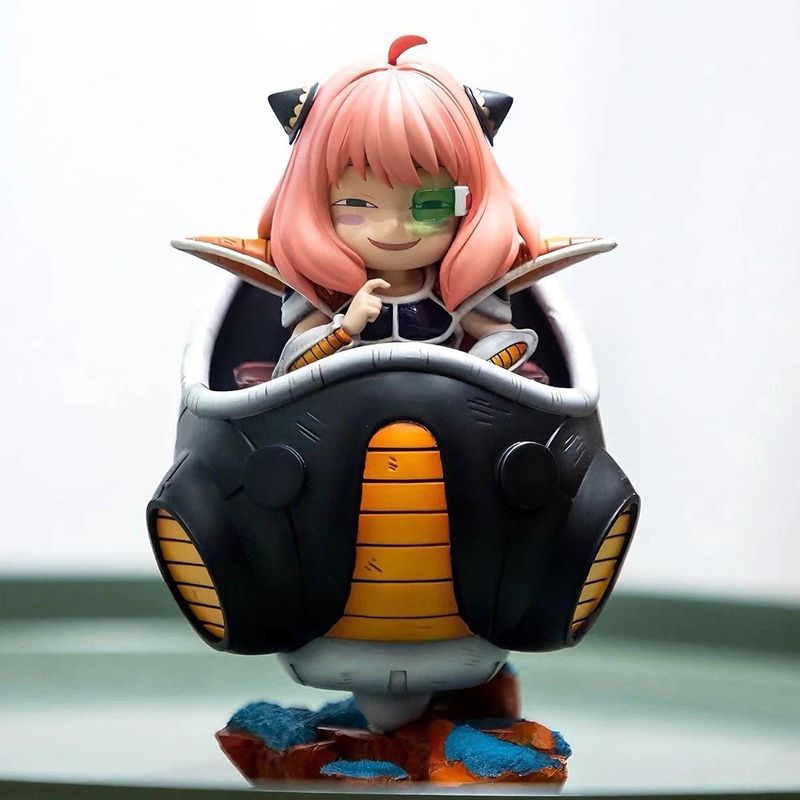 The Spy × Family Anya Forger PVC Figure, 15 cm as Frieza Cosplay, features pink hair and a green visor with a playful smile. Nestled in a mechanical egg-shaped contraption, the figure&