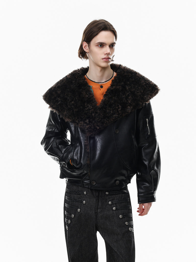 Men's oversized black faux leather bomber jacket with large faux shearling lapel collar, cropped fit, worn over an orange kni