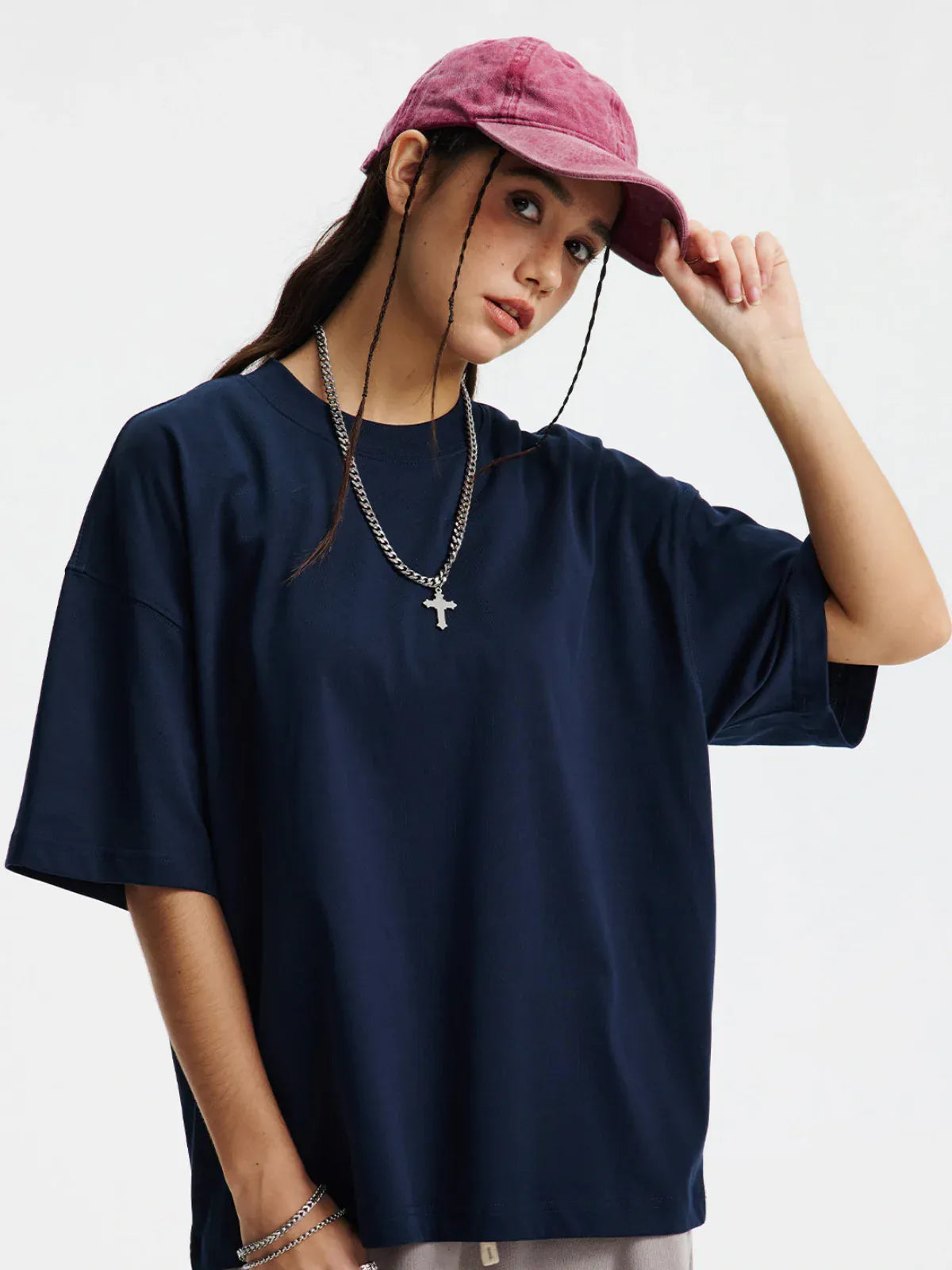 Person wears a Custom Anime Character Navy T-Shirt – Personalized 230GSM 100% Cotton Tee, styled oversized, with a pink cap and necklaces, looking at the camera with a neutral expression against a plain background.