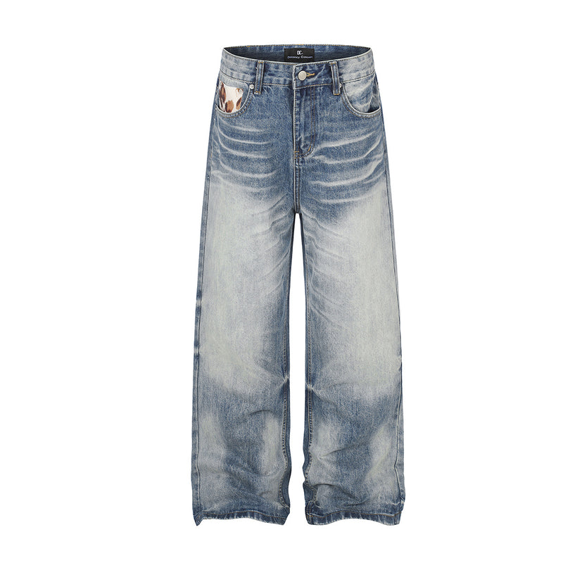 Jean baggy à jambes larges et taille mi-haute en denim bleu délavé, avec empiècements effet peau de vache et appliqués étoiles, vues de face et de dos