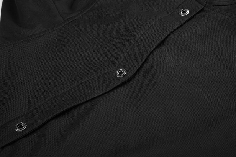 Close-up of black jacket pocket flap with three silver snap buttons