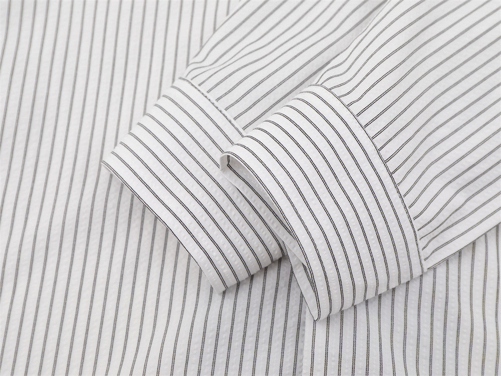 Close-up of folded white striped sleeve with buttoned cuff detail