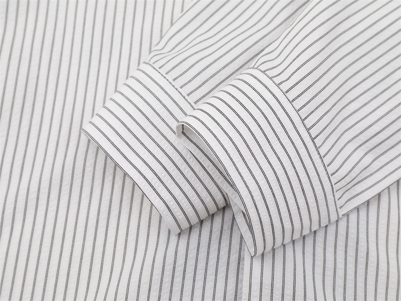 Close-up of folded white striped sleeve with buttoned cuff detail