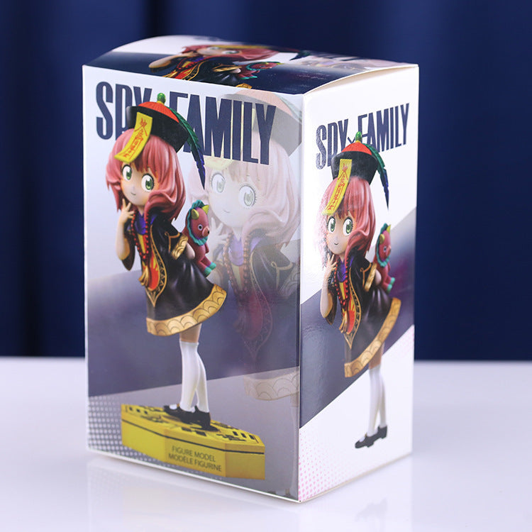 Box contains an 18 cm PVC figure model of Anya Forger in a school uniform with a toy, by Spy × Family. Features pink hair, a black dress with gold accents, white socks. The packaging showcases various images of the figure and prominently features the &quot;Spy x Family.