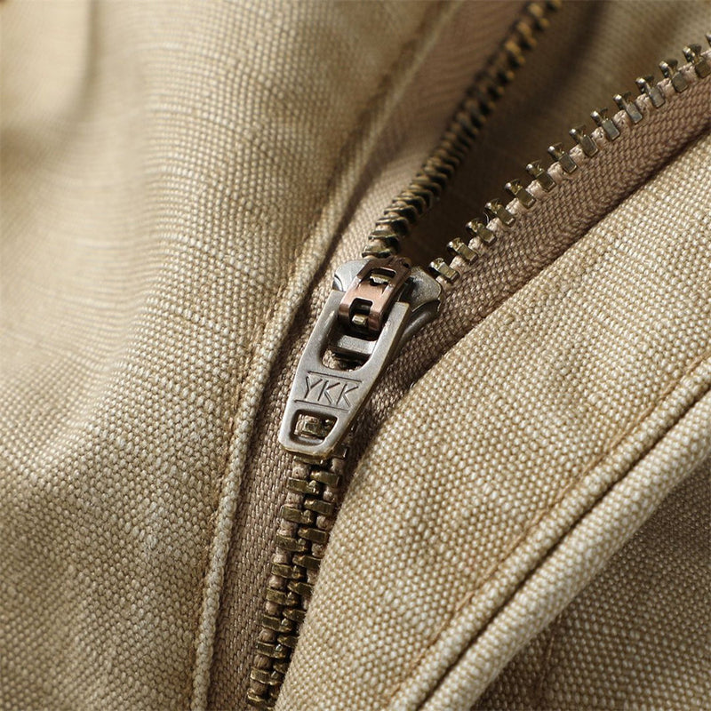Close-up of khaki cargo shorts zipper with YKK pull and canvas fabric