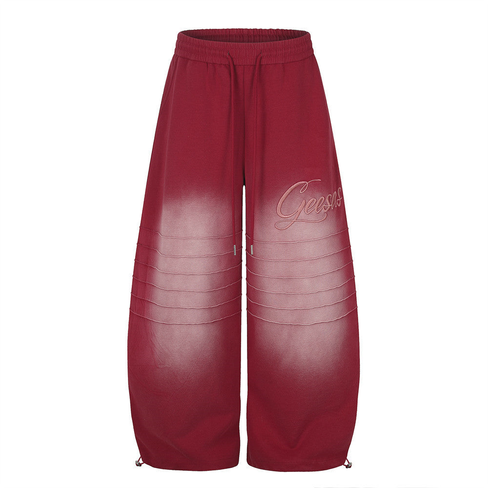 Geesas wide-leg gradient sweatpants in red with tonal script embroidery and horizontal pintuck seam detailing
