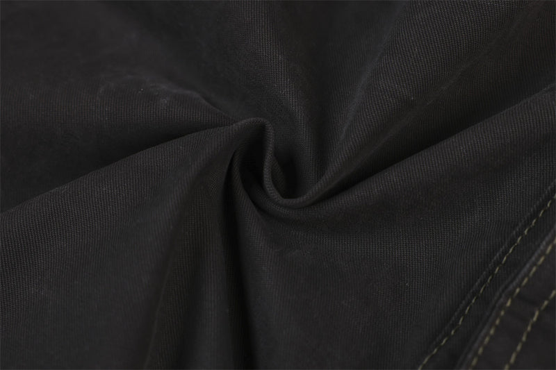 Close-up of black woven fabric texture with seam stitching