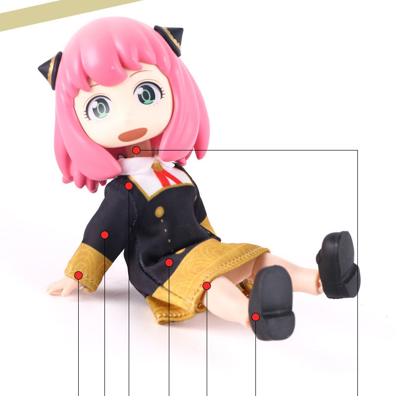 The Anya &amp; Yor Forger Nendoroid from Spy × Family features a pink-haired figure in a black and gold outfit with a red tie, completed by black shoes. Red lines and dots accentuate the design on this 13cm poseable anime collectible.