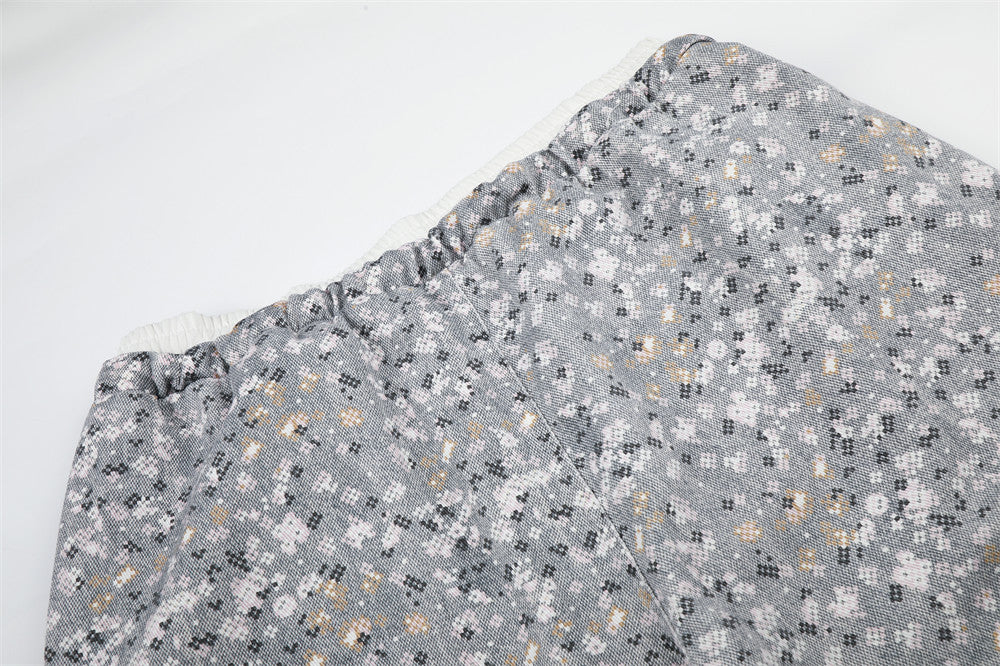 Close-up of upper pants leg with elastic waistband and floral print fabric