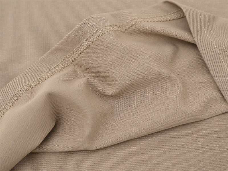 Close-up of khaki shirt side seam and smooth knit fabric