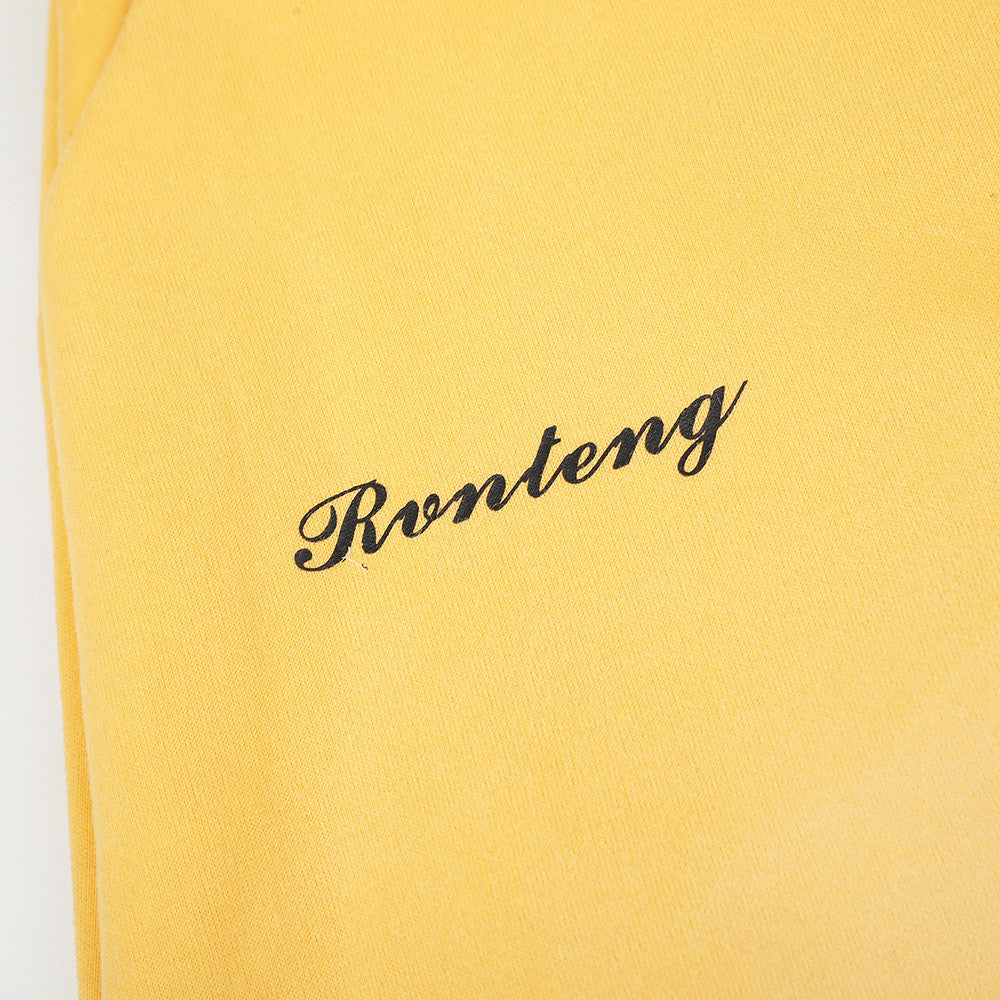 Close-up of yellow sweatpants script logo print on the leg