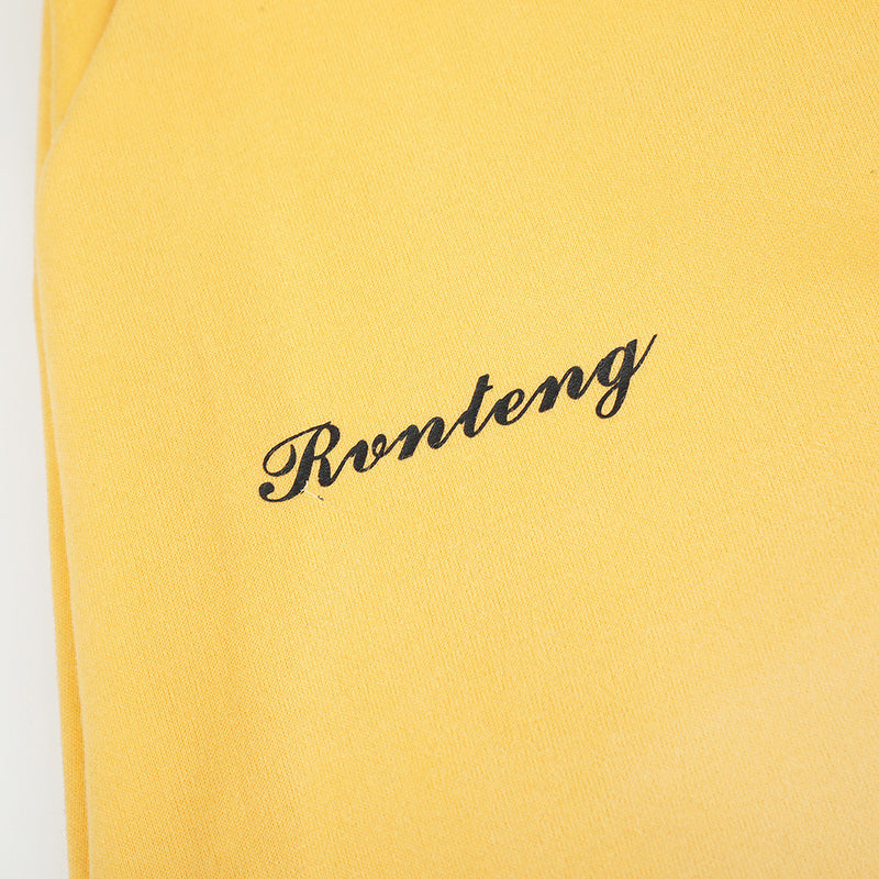Close-up of yellow sweatpants script logo print on the leg