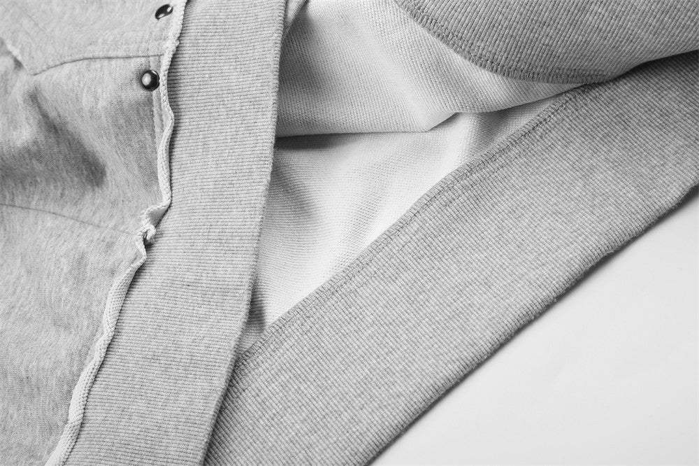 Close-up of light gray hoodie side seam and ribbed hem with visible inner fleece lining