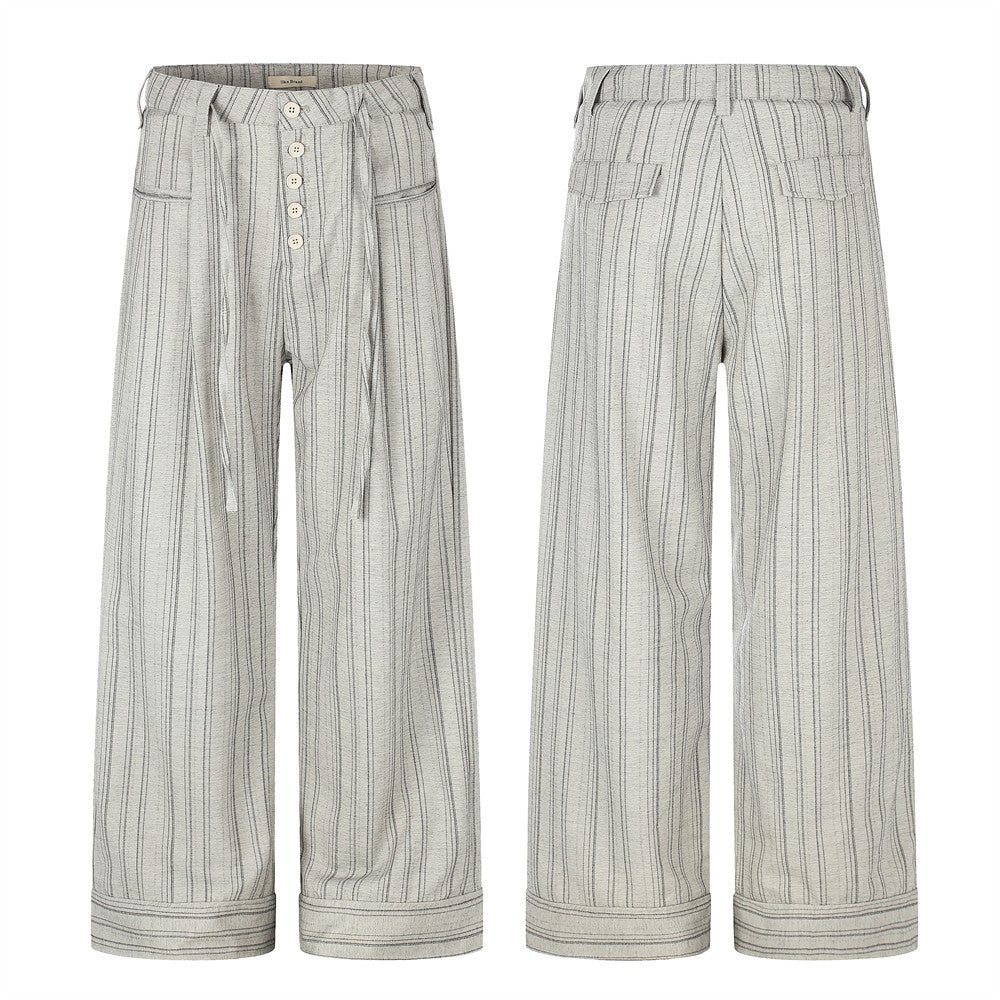 Men's wide-leg grey pinstripe trousers with button-fly, drawstring waist, patch pockets, and folded cuff hem, front and back