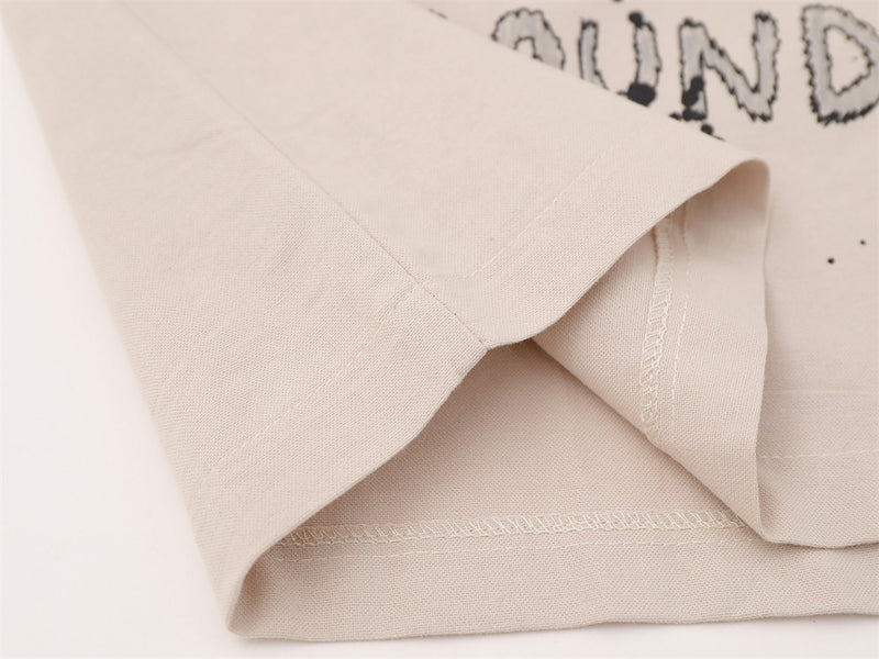 Close-up of beige shirt hem with stitched edge detail