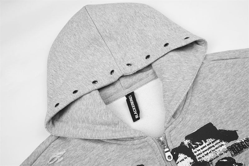 Close-up of light gray hoodie hood with black studs around the edge and zipper at the neckline