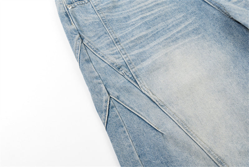 Close-up of side seam and angled panel detail on light blue baggy denim shorts