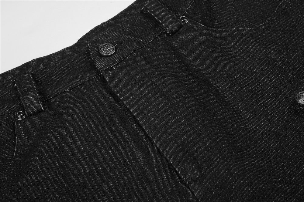 Close-up of black denim waistband, pleat seam, and front button detail