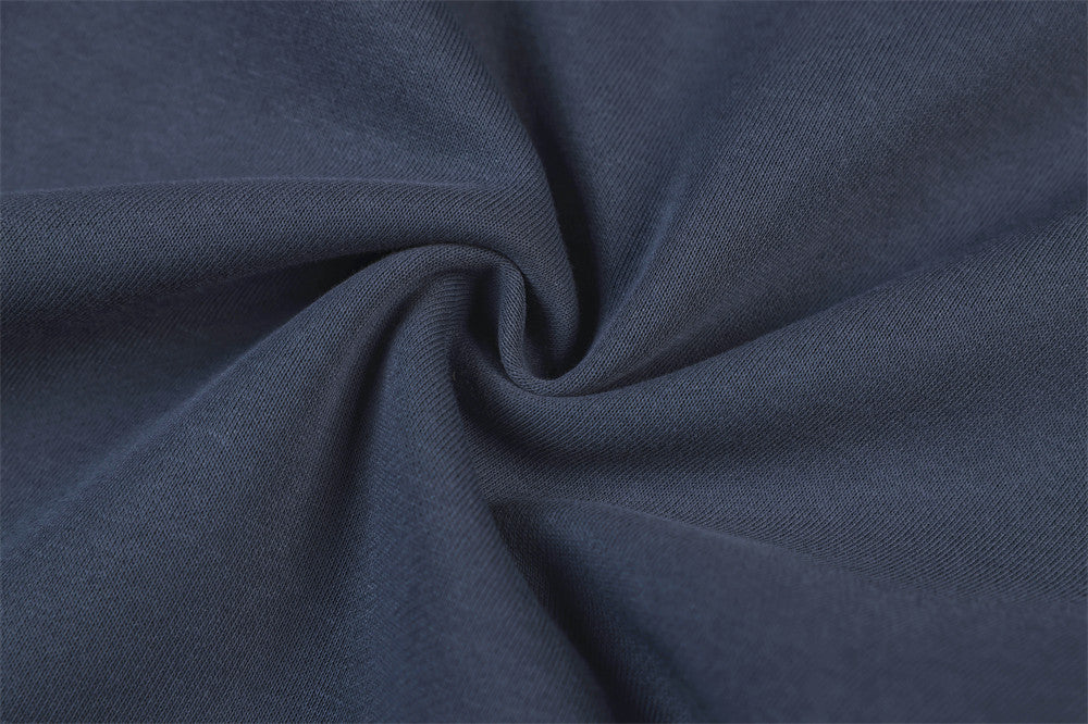 Close-up of navy track pants fabric texture with soft knit weave and gathered fold