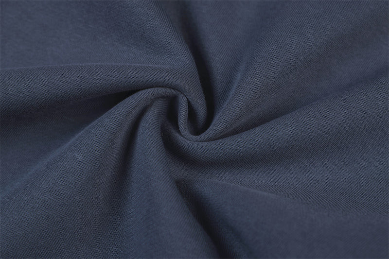 Close-up of navy track pants fabric texture with soft knit weave and gathered fold