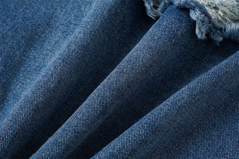 Close-up of blue denim fabric texture with a frayed edge