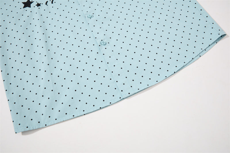 Close-up of the light blue shirt hem with black polka dot print