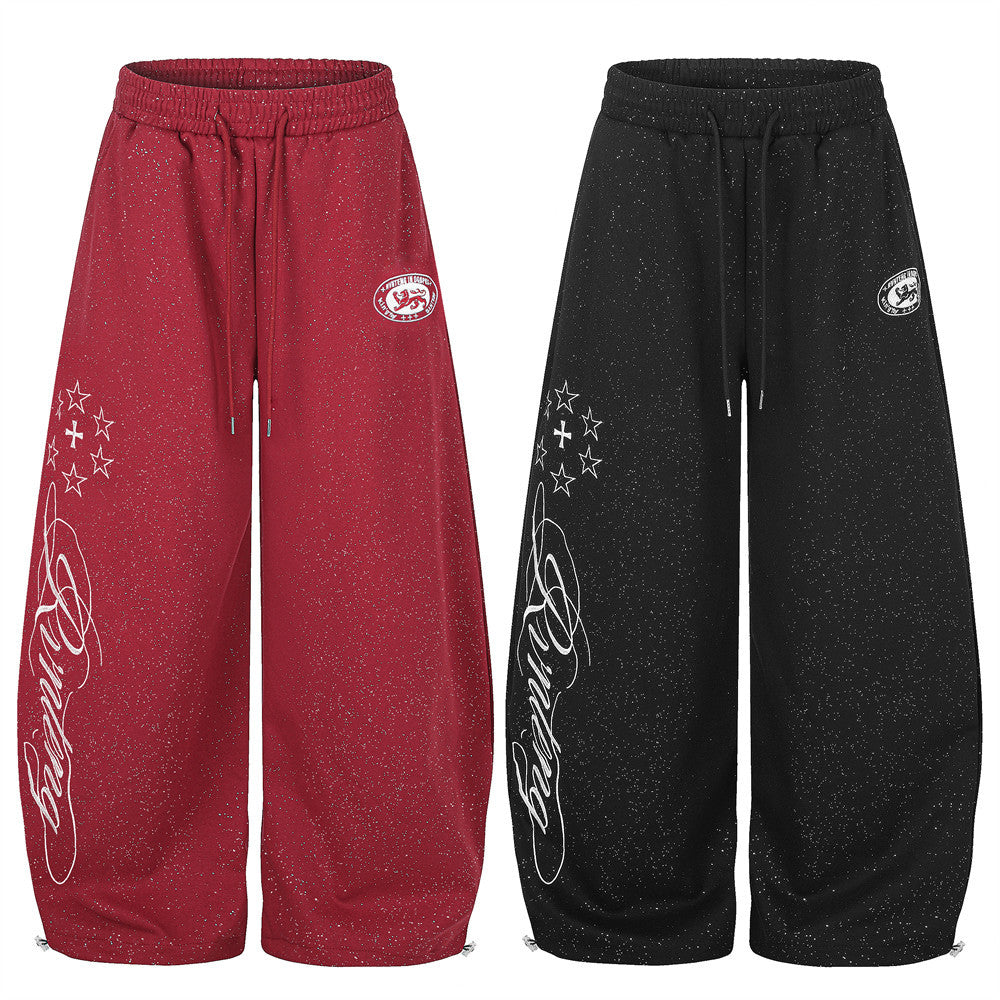 Men's wide-leg baggy sweatpants with glitter speckle fabric and star script graphic print in red and black colorways