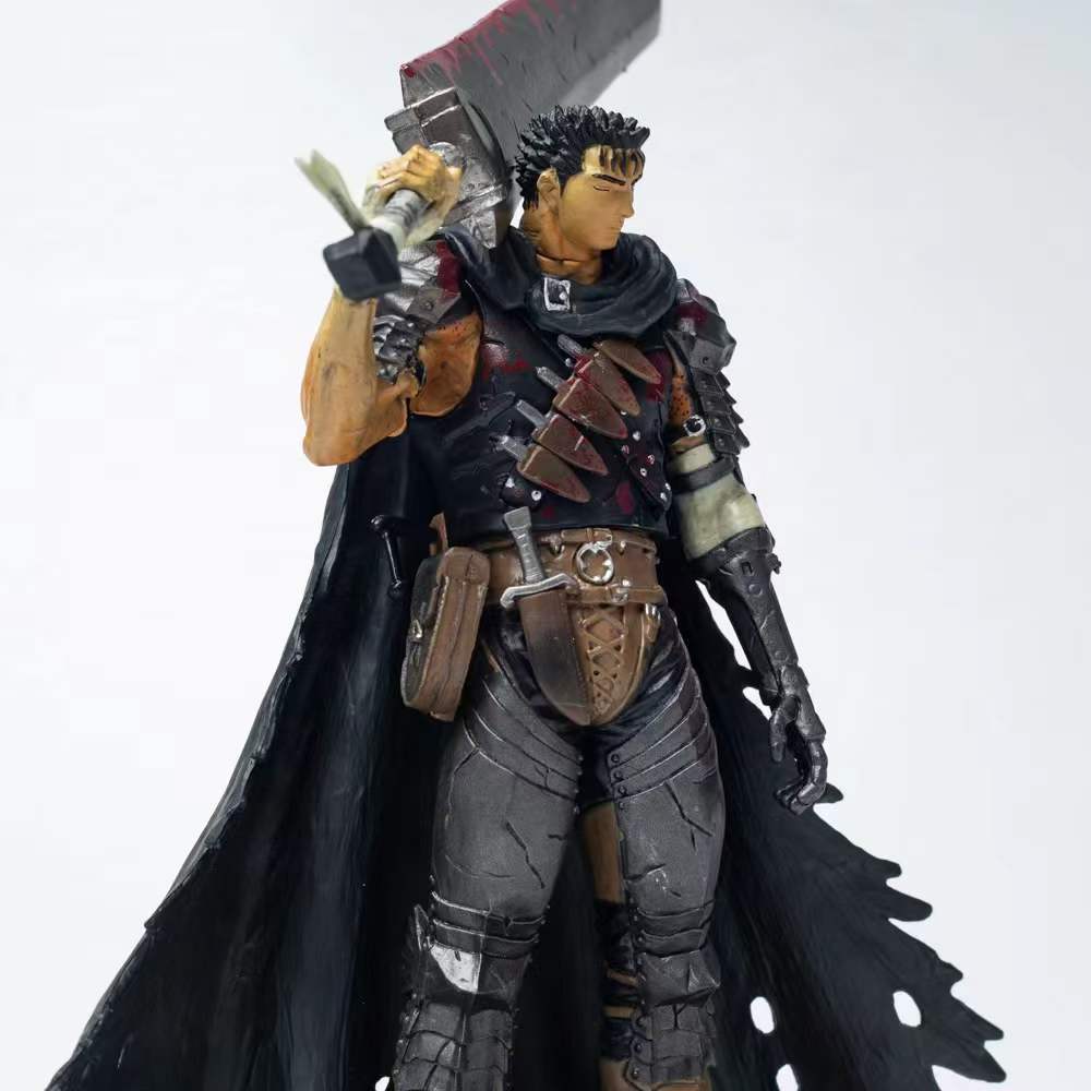 The Berserk Guts Brand Marked Bloodstained Version Action Figure depicts a berserk warrior with spiky black hair, in dark armor and a tattered black cape, brandishing a bloodstained sword over his shoulder. This 21 cm PVC statue features pouches and armor pieces against a stark white backdrop.