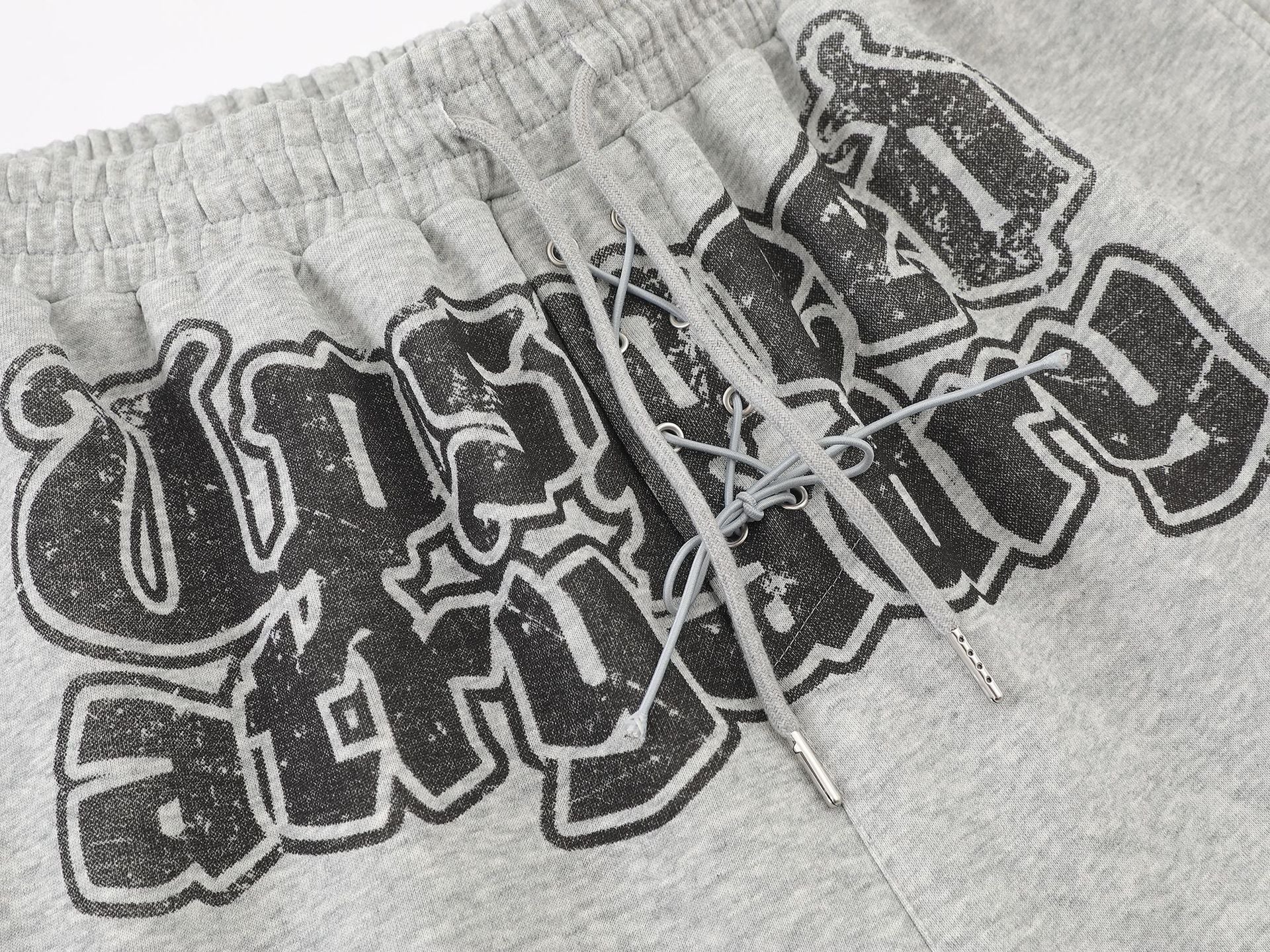 Pantalon de survêtement à jambes larges avec graphisme graffiti et ourlet orné de détails métalliques