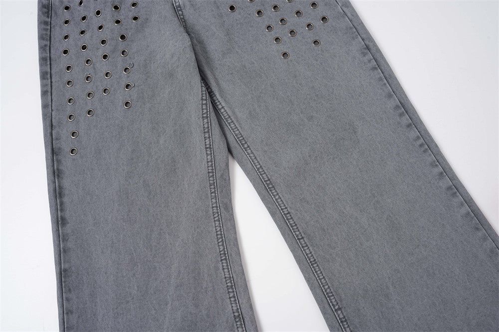 Lower leg view of washed grey jeans with metal eyelet rows near the thigh