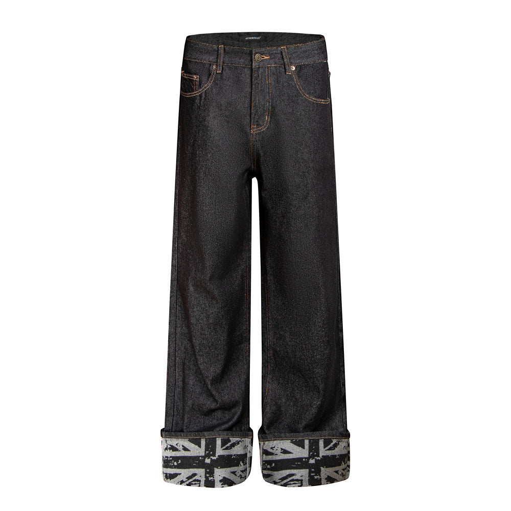 Men's wide-leg dark raw denim jeans with rolled Union Jack print cuffs and studded back pockets, front and back view