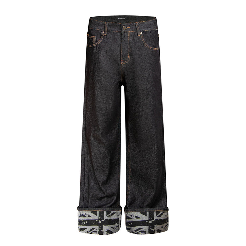 Men's wide-leg dark raw denim jeans with rolled Union Jack print cuffs and studded back pockets, front and back view