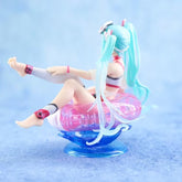 The Hatsune Miku Swimsuit with Float Ring PVC Figure features a small 11cm figure with long teal hair sitting in a translucent pink float ring. It&