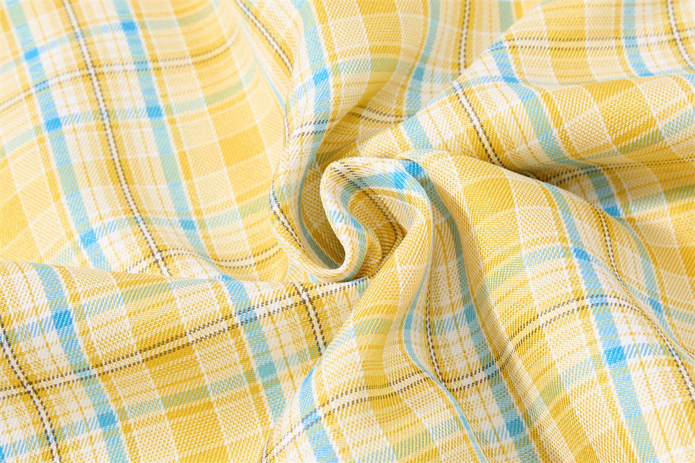 Close-up of gathered plaid fabric showing soft woven texture and folds