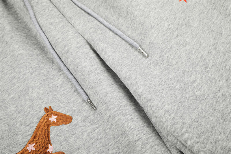 Close-up of gray sweatpants drawstrings and horse embroidery detail