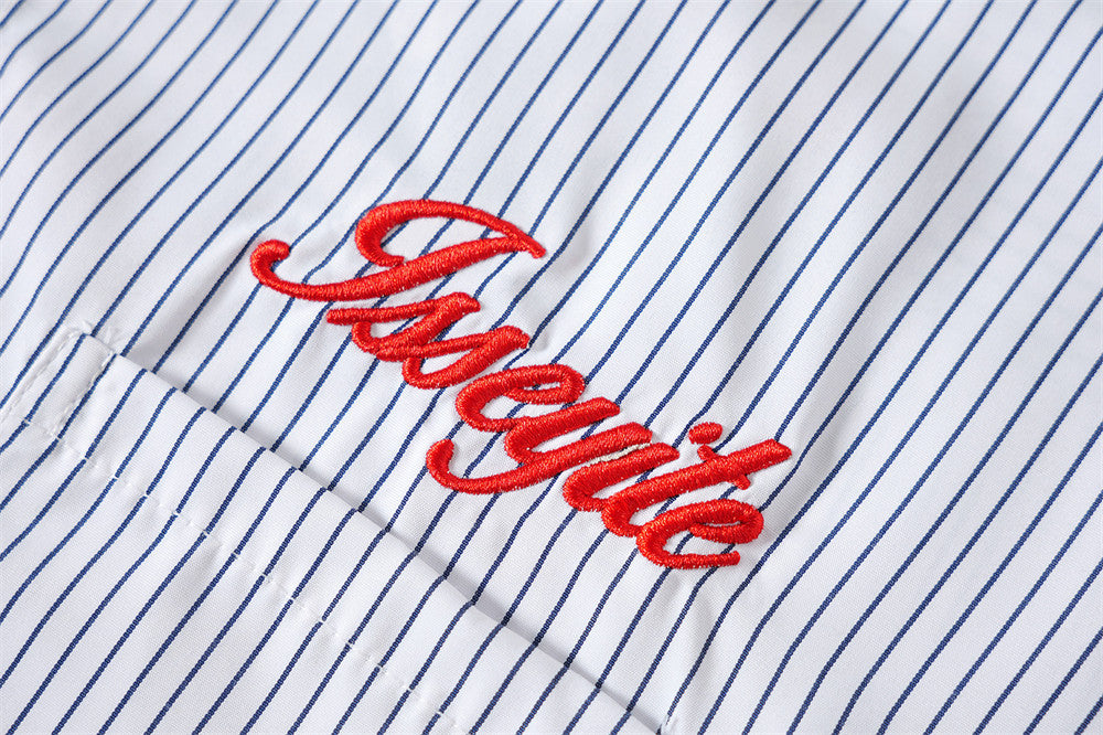 Close-up of red embroidered script on blue and white striped fabric