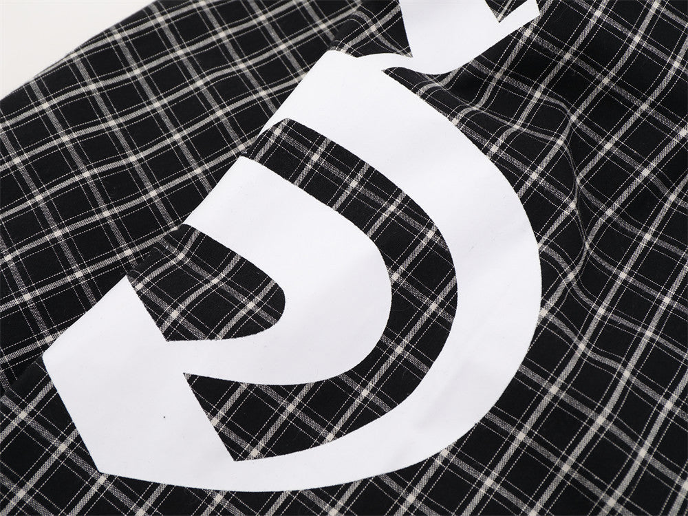 Close-up of oversized white graphic print on black plaid fabric