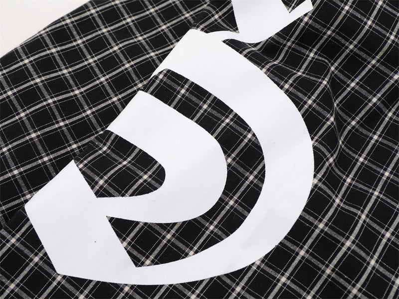 Close-up of oversized white graphic print on black plaid fabric