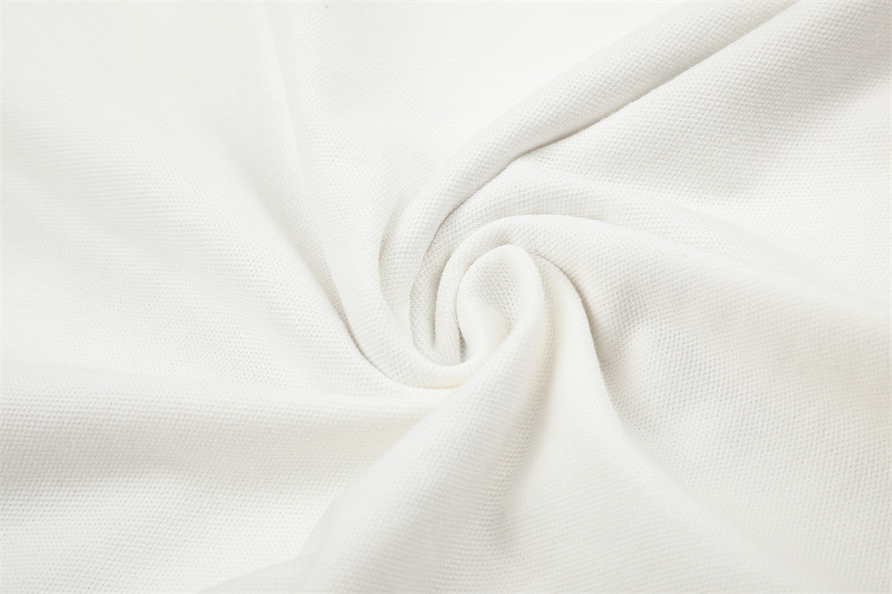 Close-up of white knit fabric texture with soft folded swirl