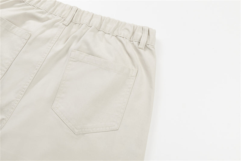 Close-up of cream pants back pocket on the right side
