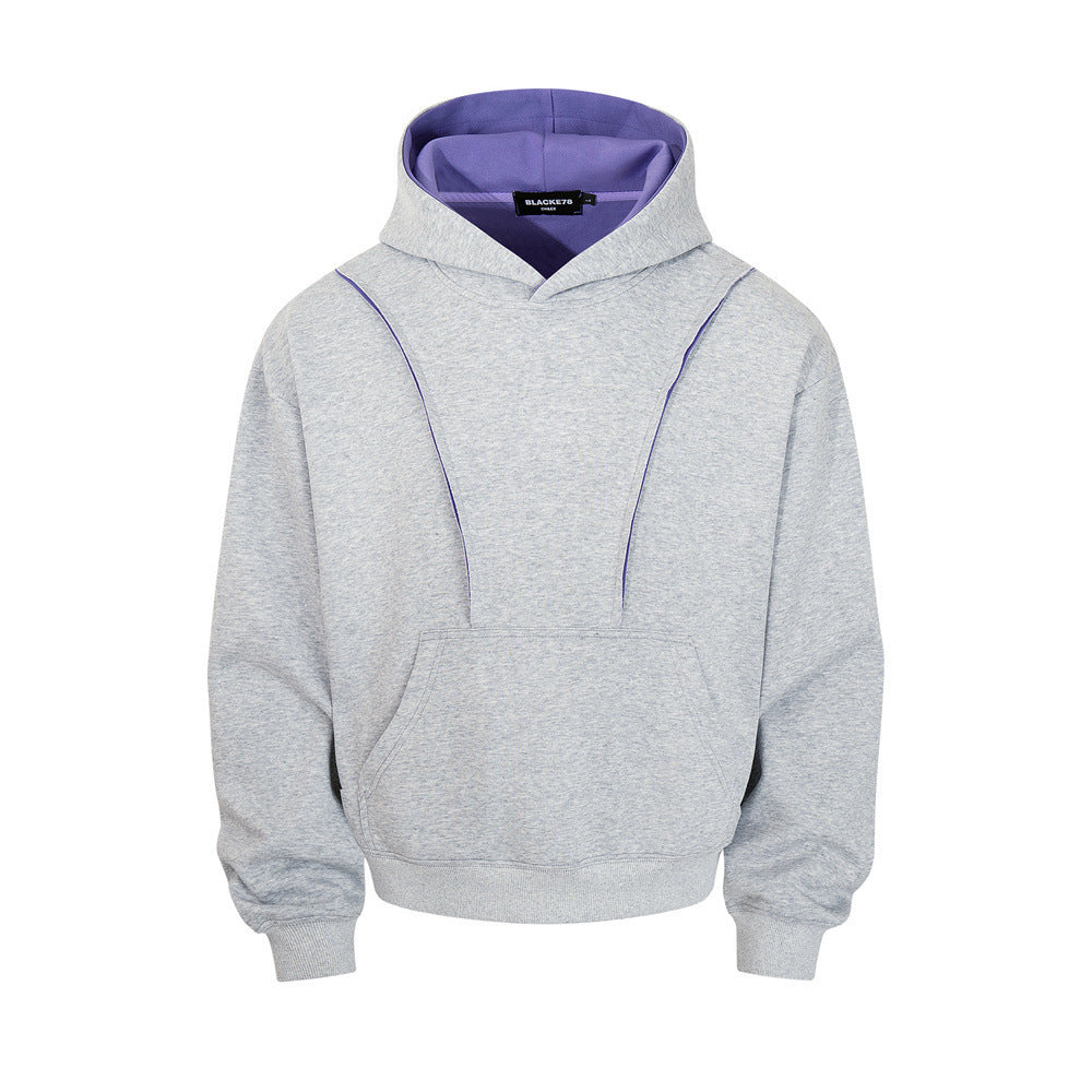 Heather grey oversized pullover hoodie with purple contrast hood lining and exposed seam detail, front view
