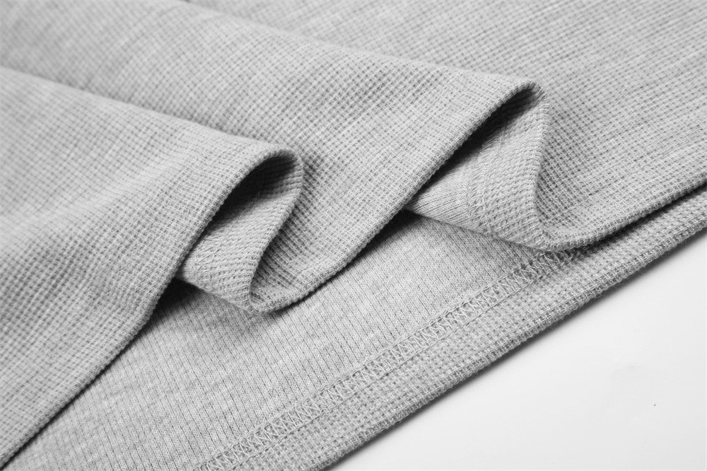 Close-up of gray tee folded sleeve seam and cuff with textured knit fabric